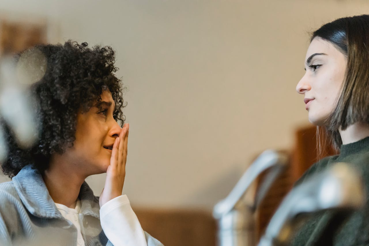 Crying black woman sharing problems with friend