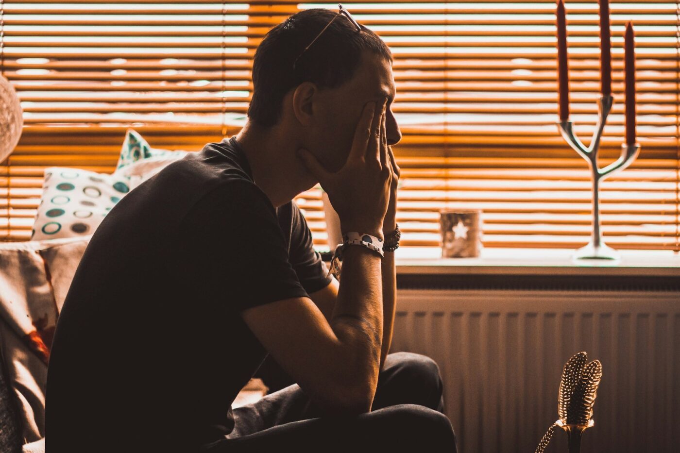 sad man in his room covering face