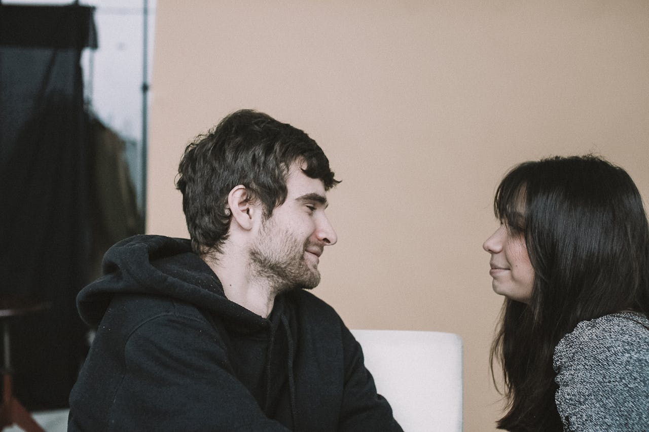 a-man-in-black-hoodie-sitting-beside-woman-in-gray-shirt